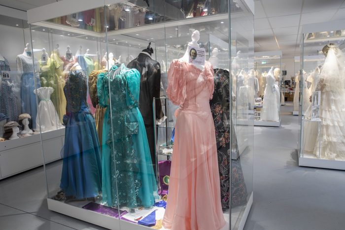 Ball gowns in pink, blue and green in a lit display case