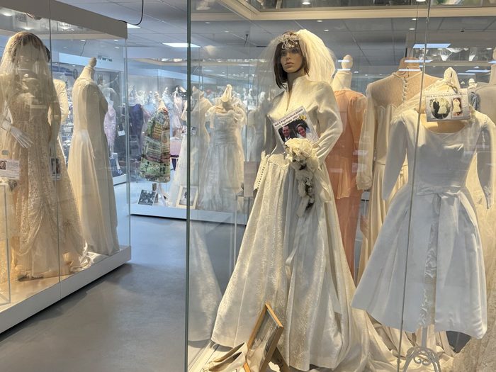 A cream bridal gown and veil on a mannequin in the clothing room