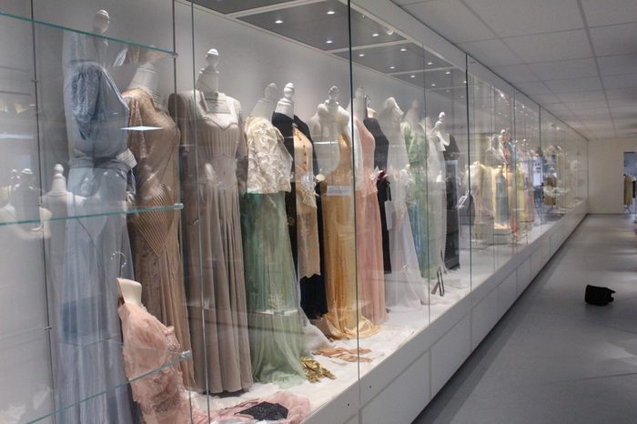 A long wall case of pale gowns running the length of the room
