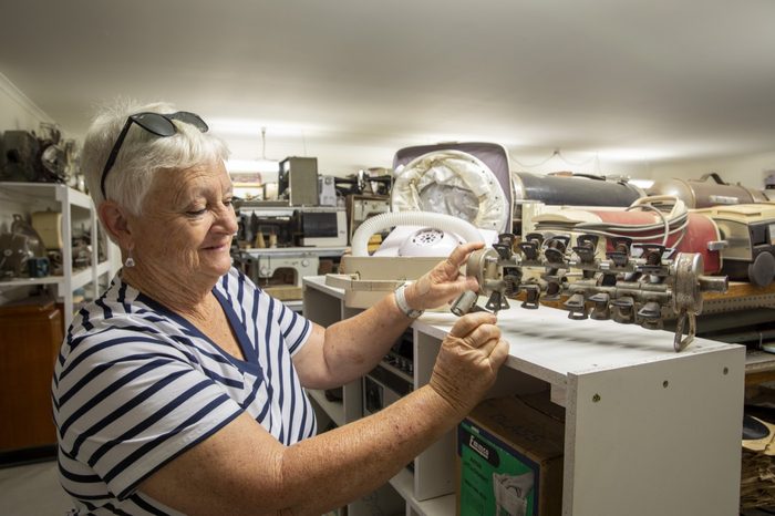 A volunteer handling a small object at the workbench display