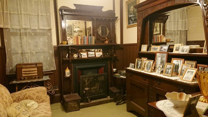 A furnished period parlour with dresser, mirror and washstand
