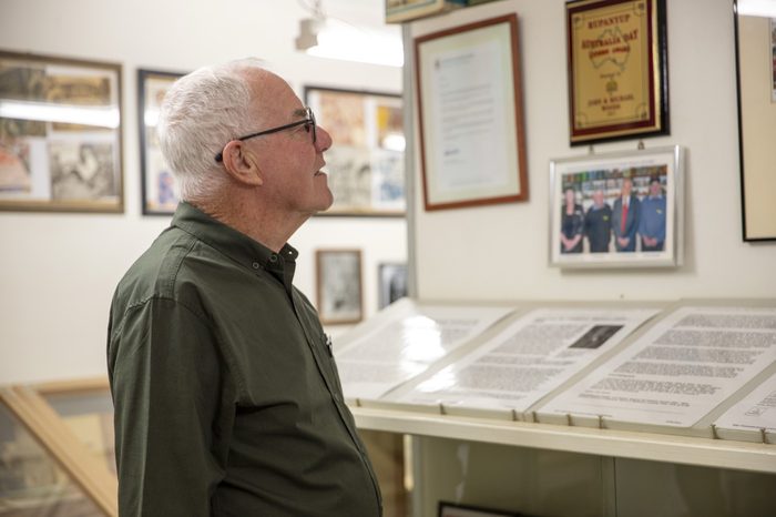 A visitor reading the museum's framed photographs and records